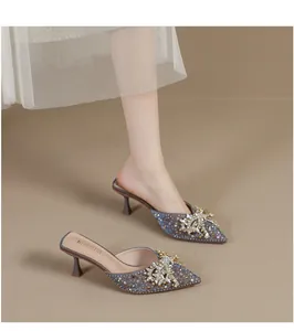 Detail van de elegante strass-vlinderstrik op de puntige muiltjes