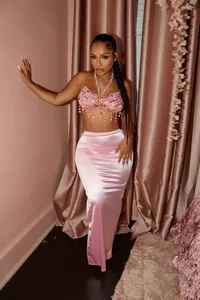 Ganzkörperansicht eines schimmernden rosa Satin-Maxirocks für einen glamourösen Look.