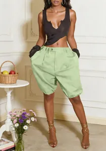 Full body view of trendy light green baggy lantern shorts on a female model in a stylish room.