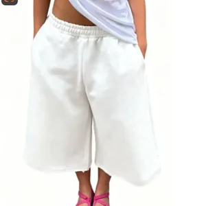 Détail d'un short de jogging blanc à jambes larges avec ourlet brut et taille élastique.