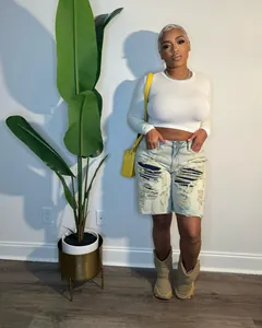 Washed distressed denim shorts with unique patchwork detail in a streetwear fashion look