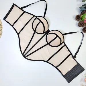 Detailed flat lay view of a beige mesh corset top with black contrast boning and straps.