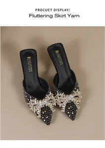 Gedetailleerde close-up van elegante zwarte puntige muiltjes met glinsterende strass strik.