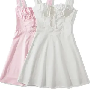 Détail de robes à bretelles douces en blanc et rose, coupe trapèze à taille haute
