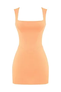 Detailed view of the square neck and structured waistline on this peach mini dress.