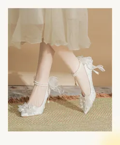 Elegant white lace wedding high heels with pearl ankle strap and floral detail