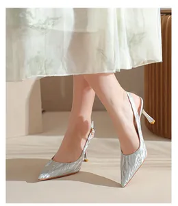 Detailed close-up of silver glitter pointed-toe slingback pumps with elegant thin high heels