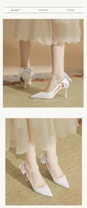 Elegant white satin bridal heels with double pearl ankle straps and silk bow detail