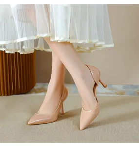 Gros plan d'escarpins en cuir verni nude avec talons aiguilles et bout pointu.