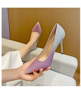 Detailansicht von funkelnden lila Stilettos mit Pailletten und Farbverlauf in der Hand