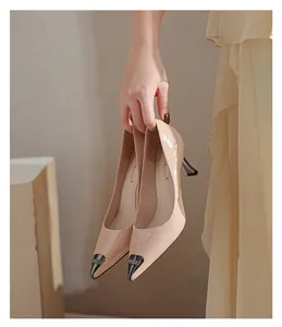 Close-up of elegant beige patent leather pointed-toe heels with crystal detail