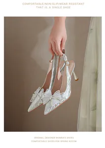 Detalle de tacones plateados con purpurina y un gran lazo de cristal brillante.