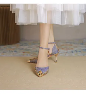 Detail view of elegant purple silk high heels with gold pointed toe and ankle strap