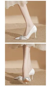 Primo piano di décolleté bianche a punta con fibbia in strass brillanti ed eleganti.