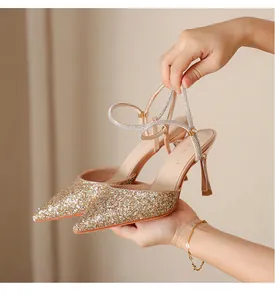 Detailed view of sparkly champagne glitter pumps with rhinestone ankle straps.