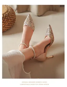 Close-up detail of elegant pointed toe glitter high heels with pearl ankle strap