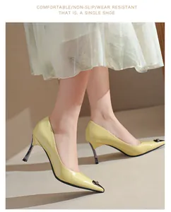 Close-up of elegant light yellow patent leather pointed-toe high heels on feet.