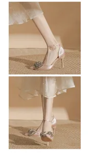 Close-up details of elegant champagne silk high heels with crystal bow