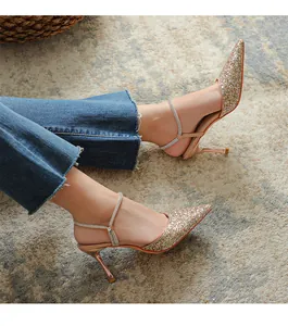 Detailed shot of fairy style gold glitter pointed-toe stiletto heels with rhinestone straps