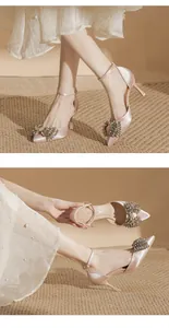 Detail of champagne satin stiletto heels featuring a large rhinestone bow and ankle strap