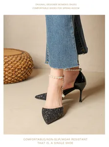 Close-up of elegant black glitter pointed toe pumps with decorative pearl ankle strap