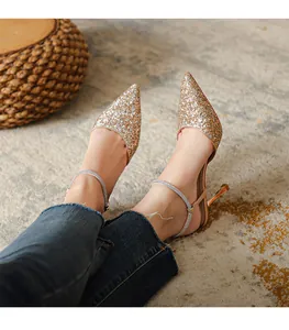 Detailed shot of sparkling champagne gold glitter heels with rhinestone ankle strap