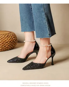 Close-up of black glittery pointed-toe high heels featuring pearl anklet strap detail