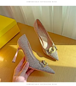 Detailweergave van geweven pumps met spitse neus en stijlvolle gouden kettinggesp