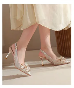 Detalle de zapatos destalonados brillantes con punta fina y lazo de cristal elegante