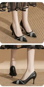 Dettaglio di eleganti scarpe nere con tacco a spillo e fibbia di strass con punta stretta.