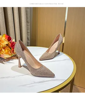 Detailed macro view of woven texture on pointed-toe stiletto pumps with slim high heels