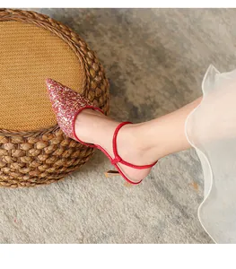 Close-up shot of elegant red glitter pointed-toe slingback heel with rhinestone strap