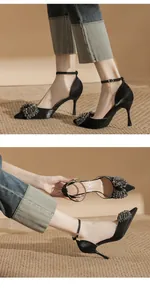 Elegant black pointed toe high heels with rhinestone flower and ankle strap.