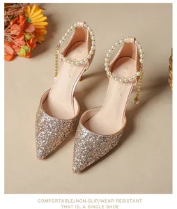 Detail of gold glitter pointed-toe high heels with pearl ankle strap and tassel