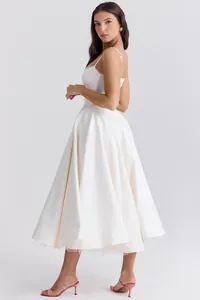 Zijaanzicht van de baleinen taille en de tule rok van een witte Franse midi-jurk.