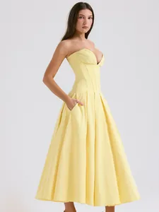 Elegante vestido de corsé amarillo brillante con falda plisada y bolsillos laterales.
