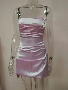 Close-up detail of a pink ruched strapless satin mini dress on a clear mannequin prop