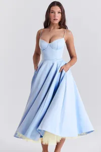 Detailweergave van het Franse korsetlijfje en de gele tule zoom op de blauwe jurk