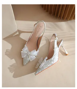 Detalle de tacones de purpurina plateada con un elegante lazo de cristal brillante.