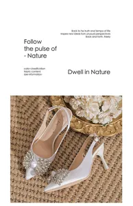 Elegant white pointed-toe stiletto heels featuring a luxurious sparkling rhinestone bow detail