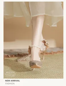 Detailed view of gold sequined bridal high heels with elegant pearl ankle strap