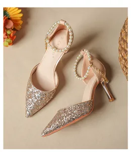 Detail view of pointed toe high heels with glitter finish and elegant pearl ankle straps.