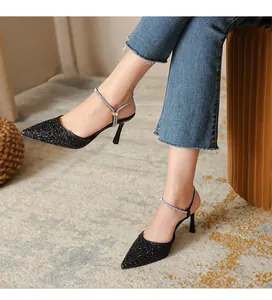 Detail view of black glitter pointed toe pumps with sparkling rhinestone ankle strap