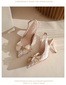 Vista detallada de tacones slingback brillantes con elegante lazo de cristal.