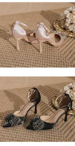 Detailed view of elegant pointed toe stiletto pumps featuring crystal toe decor and ankle straps