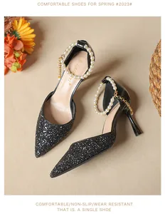 Close-up of black glitter pointed toe high heels with elegant pearl ankle straps