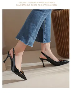 Gros plan sur des escarpins slingback en cuir verni noir avec boucle mors dorée.