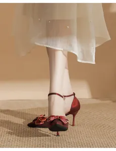 Elegante Detailansicht der roten Stöckelschuhe mit Schleife und zartem Knöchelriemen-Design