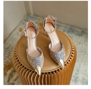 Close-up detail of elegant blue satin stiletto heels with gold metal pointed toe cap