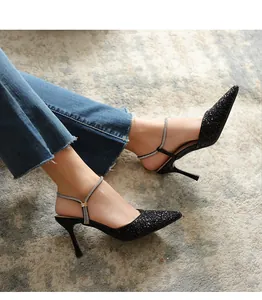 Elegant detail of black glitter pointed toe stiletto heels with rhinestone straps